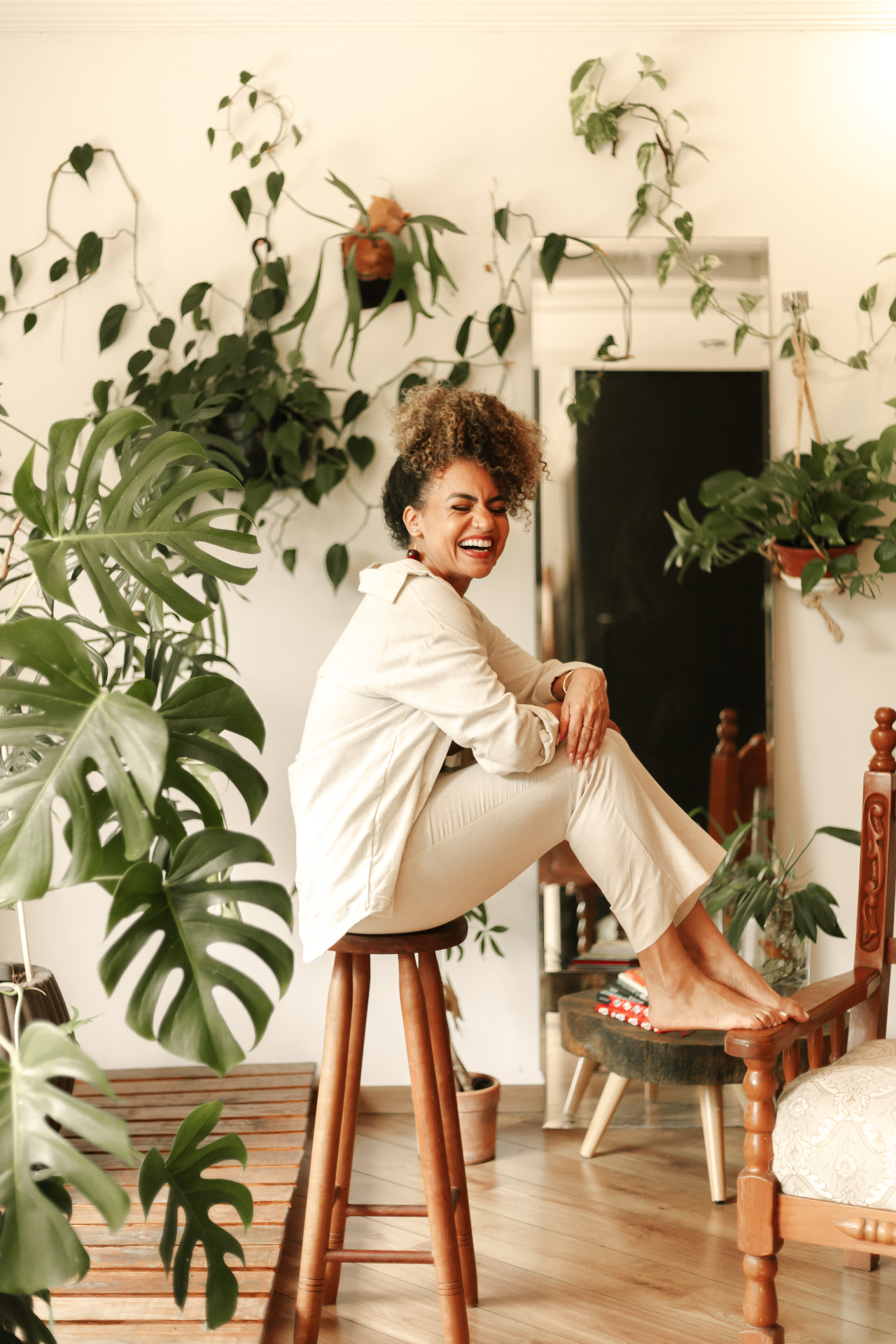 Paula Rodrigues sorrindo em um ambiente acolhedor com plantas